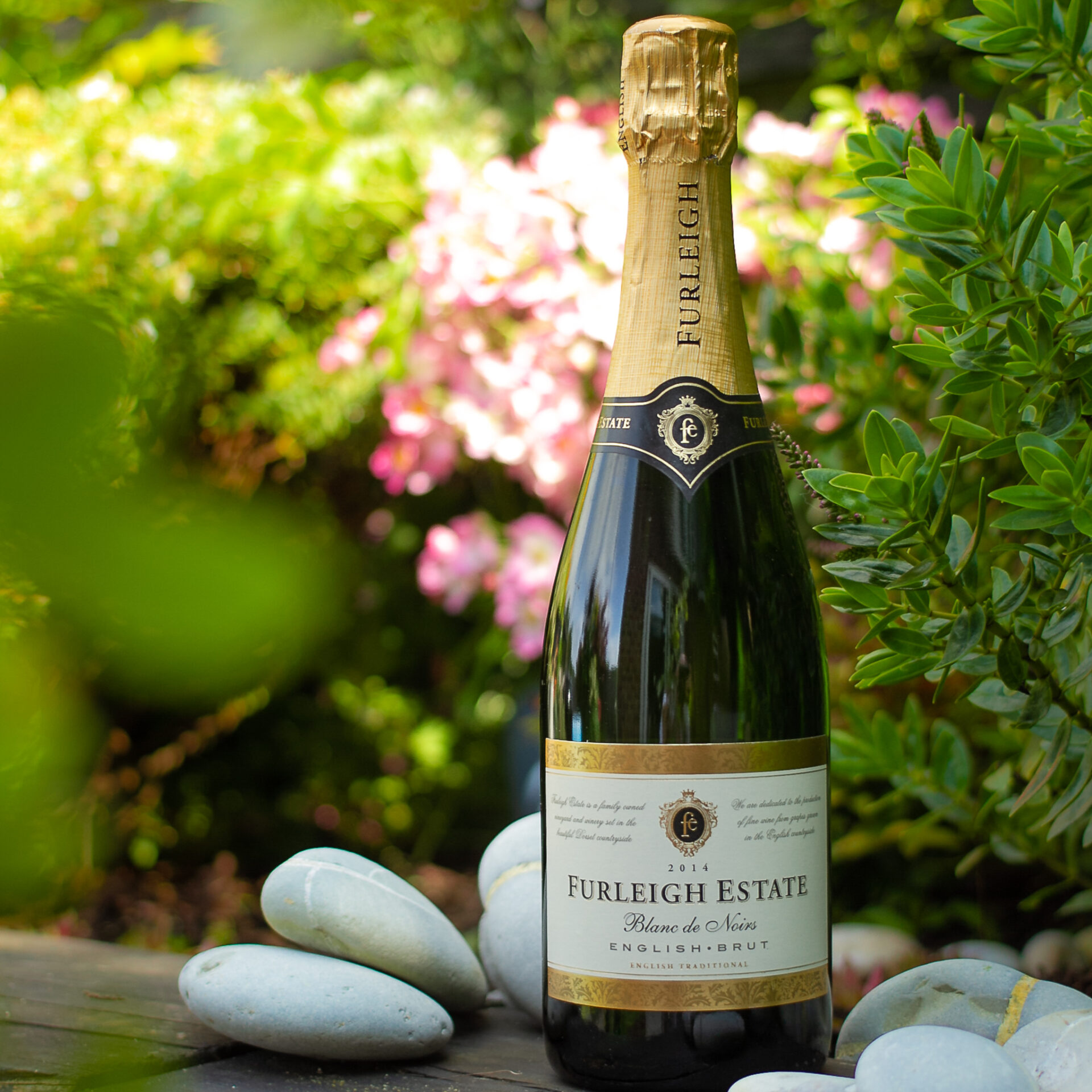 One bottle of Furleigh Estate wines in a scenic garden photo